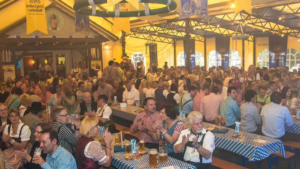 Volles Festzelt mit gemeinsam feiernden Gästen
